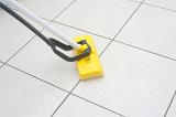 Kitchen mop being used to clean a modern white tiled kitchen floor
