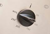 Closeup of a plastic oven thermostat dial for controlling the temperature of the appliance during the cooking of food