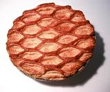 Overhead view of a golden freshly baked fancy gourmet pastry pie crust with a decorative repeat pattern
