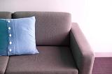 Blue cushion with button decoration on a comfortable settee, close up view