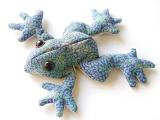 Soft toy frog made of mottled blue fabric lying splayed out on a white background