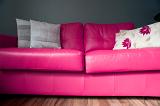 Low angle floor level view of a colorful bright pink lounge suite with stylish floral cushions
