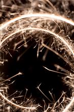 looking through spiral of sparkler trails against a black background with copyspace