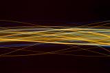 a complicated ribbon of overlapping and interweaving waves of yellow and blue light