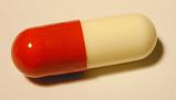 Panoramic Close Up of Red and Off-White Antibiotic Medication Capsule on Plain Background