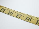 Close Up of Yellow Tape Measure Angled Across White Background, Used in Textile and Construction Industry
