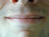 Close up of the smile of a man with unshaven stubble