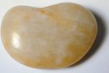 Polished quartzite stone worn smooth by the tumbling action of water in the ocean or a river, overhead view on white
