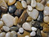 Background texture of smooth water worn pebbles from a beach or riverbed in different shapes and sizes