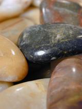 a background of smooth rounded polished pebbles of assorted colours