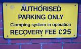 Warning sign for Authorised Parking Only noting that there is clamping in place with a fine for vehicle recovery