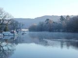a restful winter scene, still water and trees, lake windermere, uk