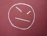 a chalk drawn face sign depicting frustration, anger or bad mood
