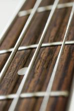 an extreme closeup on metal strings on a bass guitar