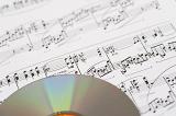 an audio cd on a background of printed sheet music
