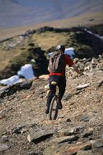 a unicyclist negotiating the side of a mountain