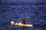 a man paddling through the water on a yellow ocean kayak