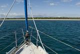 sailing a yacht towards a coral island
