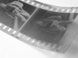 Close up of an exposed 35mm negative film strip with frames of a person and sprocket detail in a photography concept