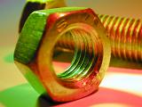 Nut and bolt in macro close-up, lit up with green and red colors. Engineering background concept