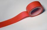 Red insulating tape with unrolled end viewed in close-up on white background
