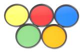Set of round colored glass photographic filters in yellow, red, blue, green, and orange isolated on white