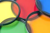 Five colorful photographic filters in red, blue, yellow, orange and green viewed close up and overlapping in a full frame background