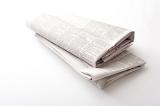 Close up of two folded printed newspapers against a white background
