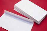 Pile of blank white envelopes on a red background waiting to be filled with circulars or correspodence