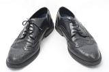 Smart black leather business shoes with a punched pattern for the fashionable man on white
