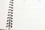 Open blank spiral bound notebook with lined pages ready for your text or message