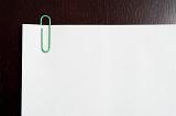 Blank paper with green paperclip on it - copy space