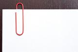 Red paperclip on blank paper with copy space