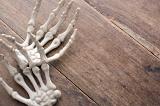 halloween boney hands on a rustic wooden backdrop