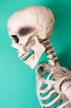 a spooky halloween skeleton head and body with a green background